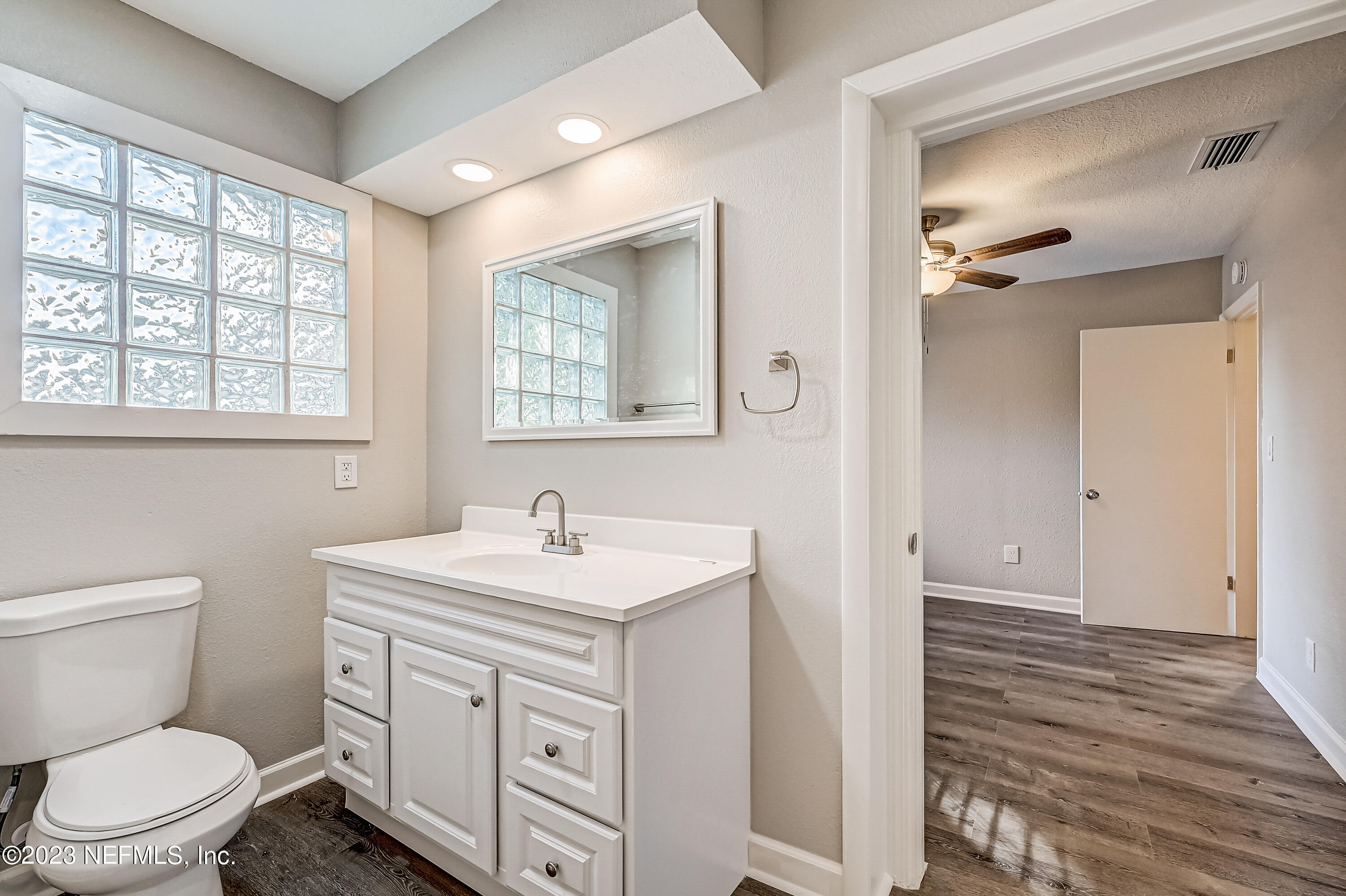 6105 Duke Road Jacksonville, FL 32217 - Photo 25 of 29 a bathroom with a toilet a sink a vanity and mirror