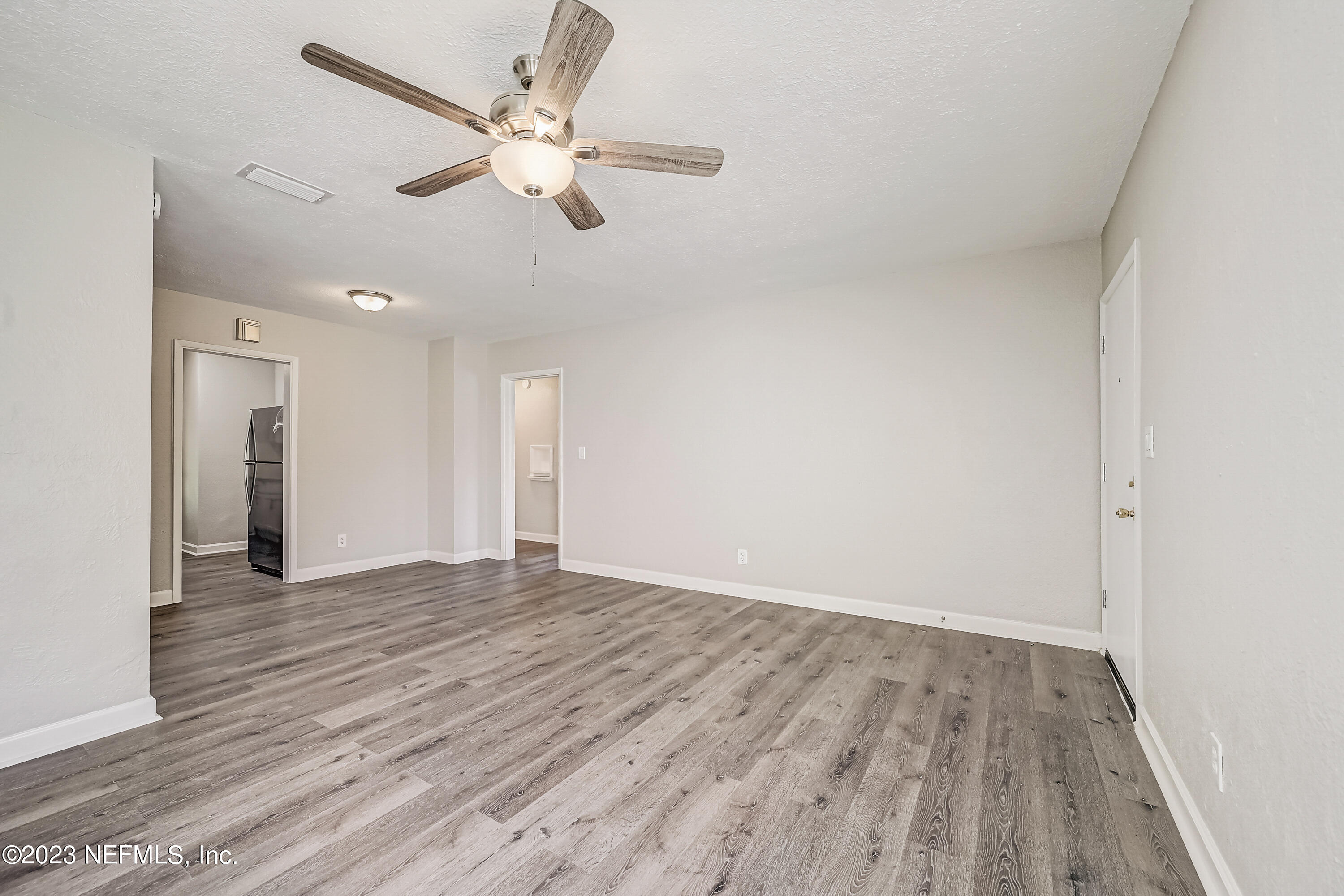 6105 Duke Road Jacksonville, FL 32217 - Photo 6 of 29 an empty room with wooden floor ceiling fan and windows