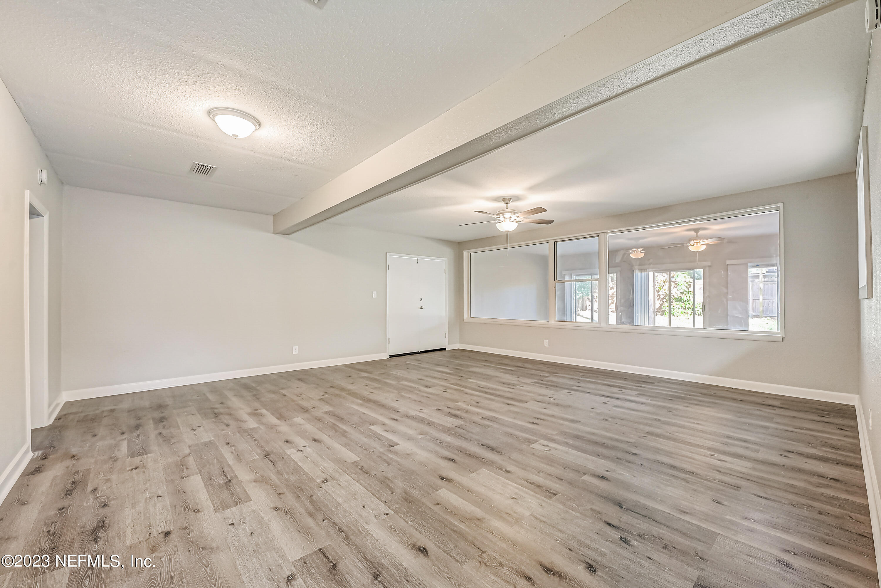 6105 Duke Road Jacksonville, FL 32217 - Photo 8 of 29 an empty room with wooden floor and windows