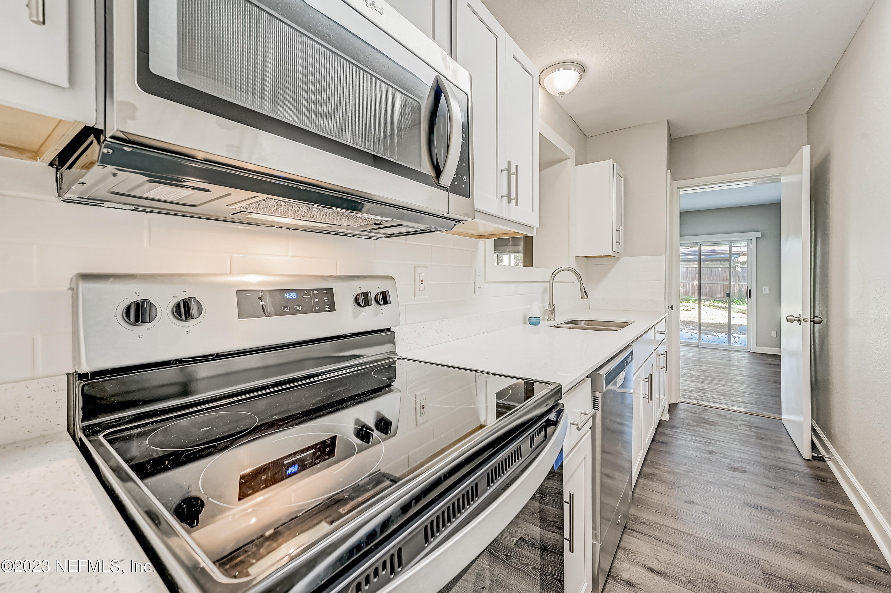 6105 Duke Road Jacksonville, FL 32217 - Photo 10 of 29 a kitchen with a stove cabinets and wooden floor