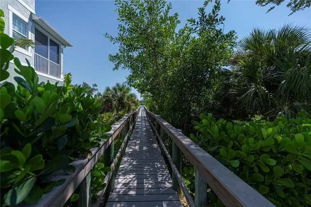a view of a dining room with furniture a chandelier and large windows