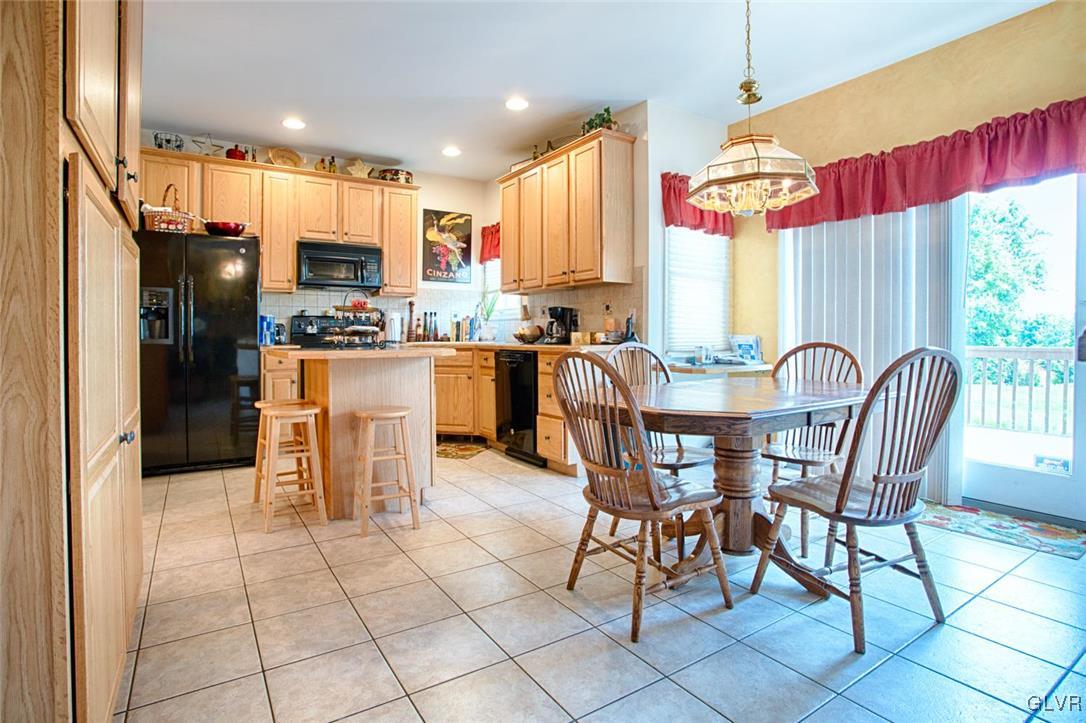 1068 Miller Road Wind Gap, PA 18091 - Photo 8 of 40 a kitchen with stainless steel appliances kitchen island granite countertop a refrigerator a stove a sink dishwasher with a dining table and chairs