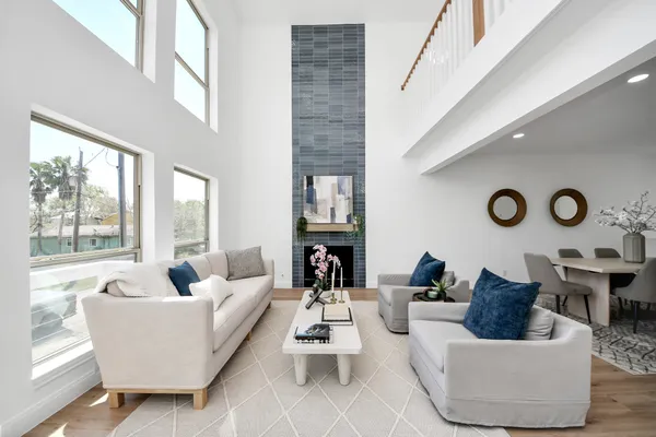 a living room with fireplace furniture and a large window