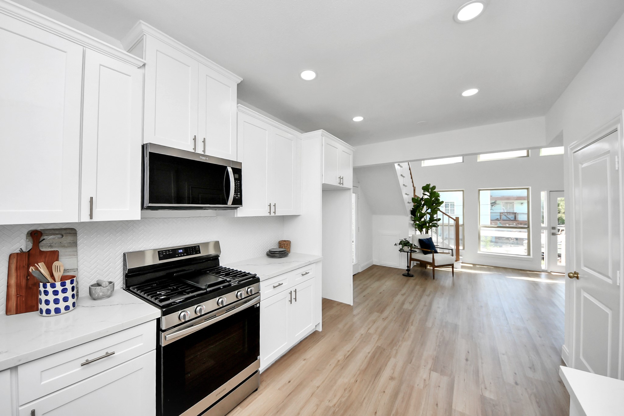 300 Narcissus Road Kemah, TX 77565 - Photo 25 of 47 a kitchen with stainless steel appliances a white stove top oven a sink dishwasher and a microwave with wooden floor