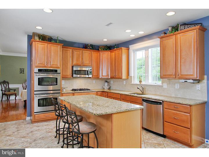 160 Prairie View Lane Mickleton, NJ 08056 - Photo 7 of 20 a kitchen with stainless steel appliances granite countertop wooden cabinets a stove top oven a granite counter top and a view of living room
