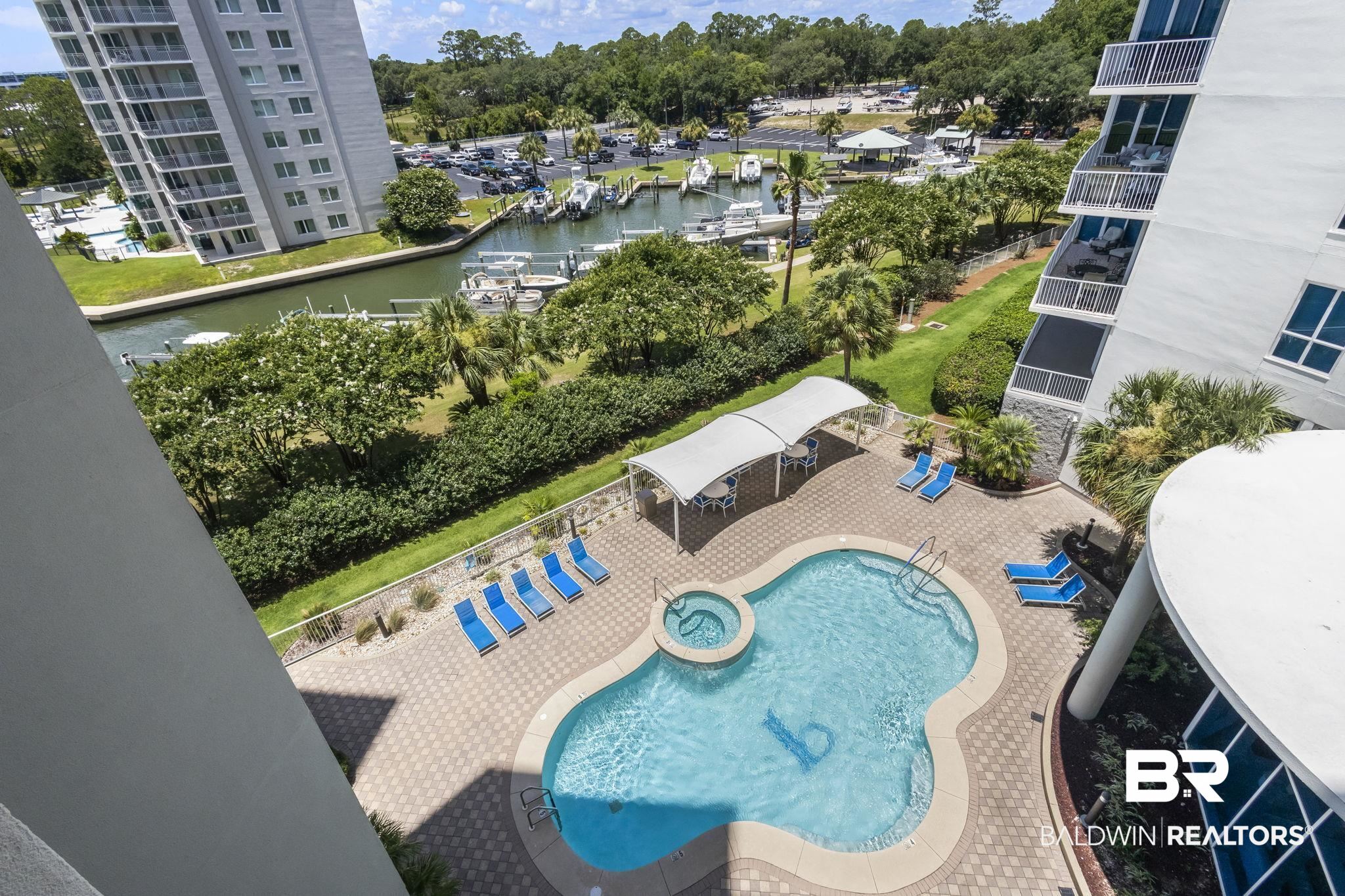 28250 Canal Road, Unit 403 Orange Beach, AL 36561 - Photo 48 of 54 View of swimming pool featuring a water view, a patio area, view of scattered trees, and a pool with connected hot tub
