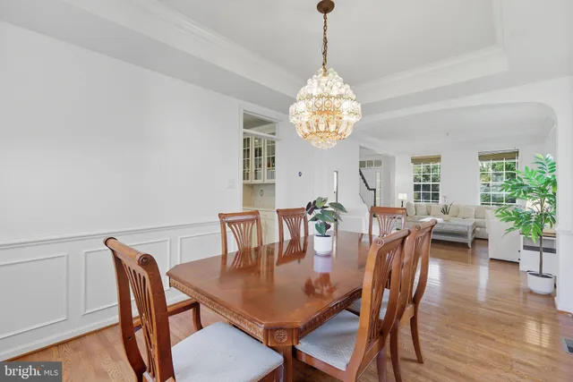a dining room with furniture a chandelier and wooden floor