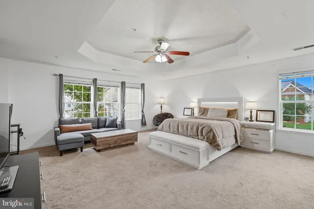 a spacious bedroom with a bed and glass windows