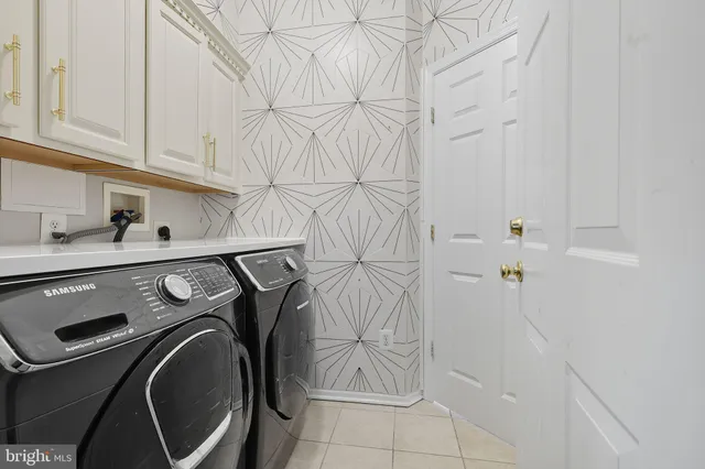 a view of a yard in front of a house with plants and large trees
