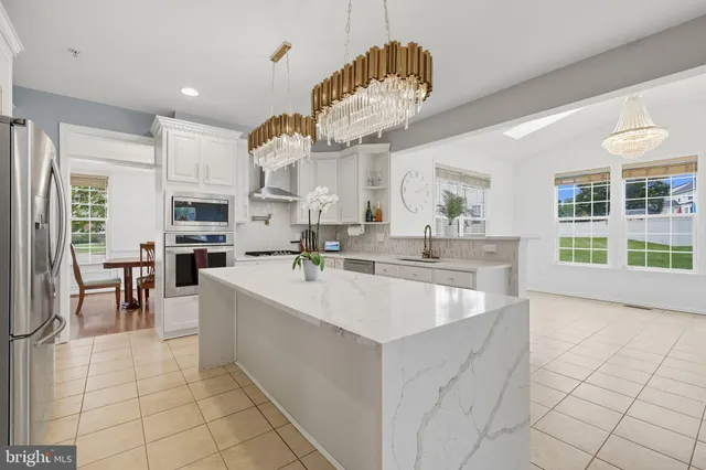 a large white kitchen with lots of counter space and breakfast area