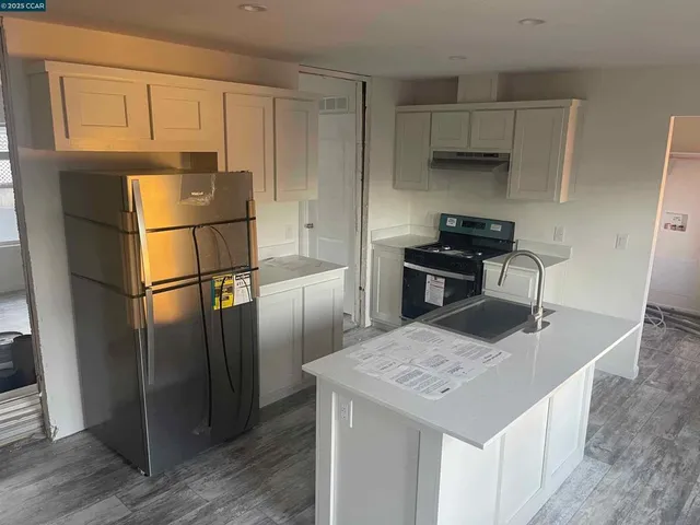 a kitchen with stainless steel appliances granite countertop a refrigerator a stove a sink and a refrigerator