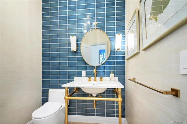 a bathroom with a sink a toilet and a mirror