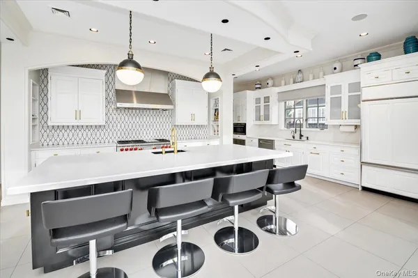 a kitchen with a dining table chairs sink and white cabinets