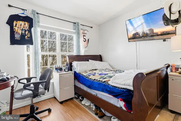 a bedroom with a bed and wooden floor