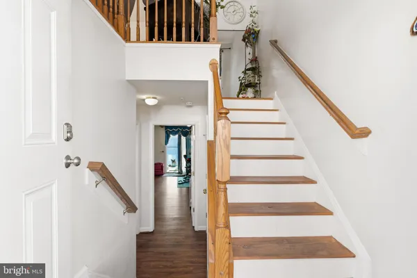 a view of entryway and hall with wooden floor