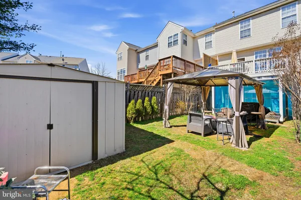 a view of a chair and table in backyard of the house
