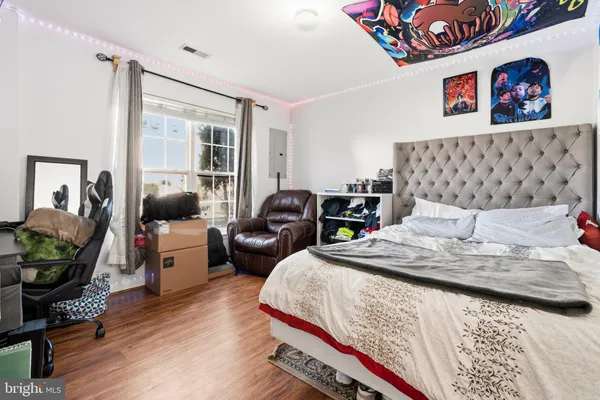 a bedroom with bed and wooden floor