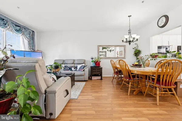 a living room with furniture a chandelier and a dining table