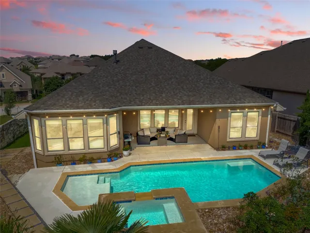 a view of a house with swimming pool and sitting area