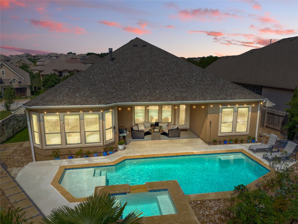 a view of a house with swimming pool and sitting area