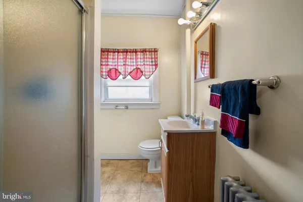 a bathroom with a toilet sink vanity and mirror