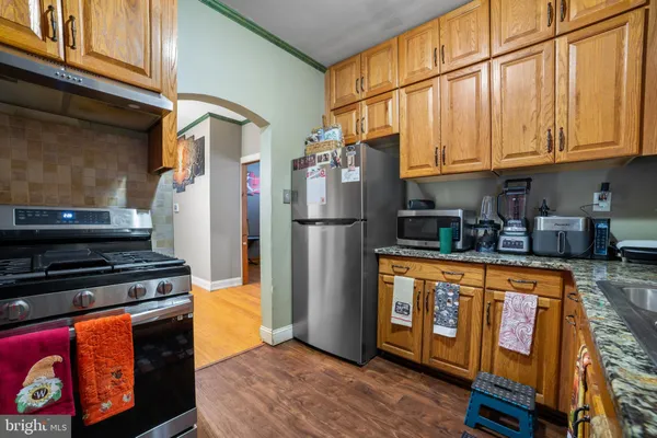 a kitchen with stainless steel appliances granite countertop a refrigerator stove and sink