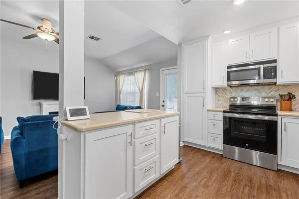 a kitchen with stainless steel appliances a stove microwave and refrigerator