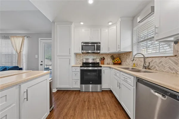 a kitchen with a sink a stove and cabinets
