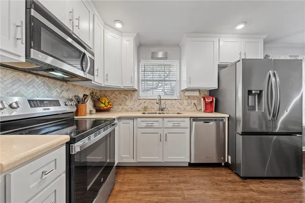 a kitchen with a sink stove and refrigerator