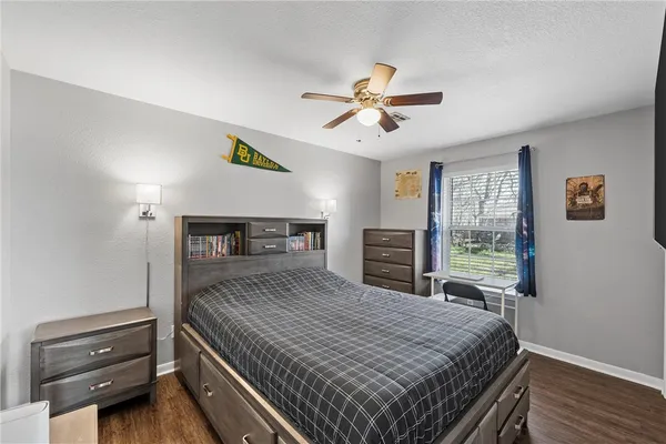 a bedroom with a bed a dresser and a window