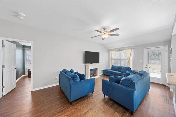 a living room with furniture flat screen tv and wooden floor