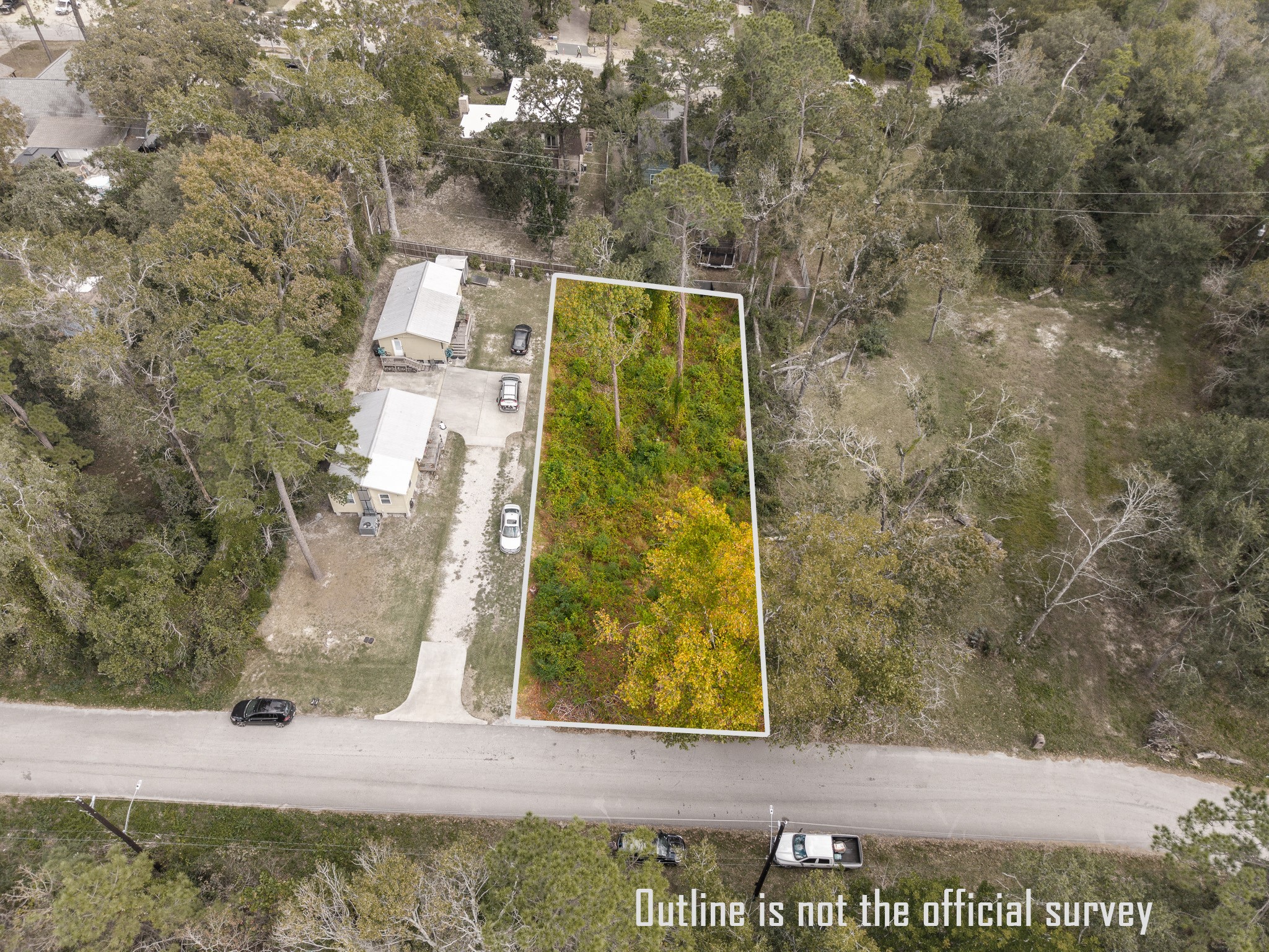 22030 Rustic Bridge Lane Houston, TX 77339 - Photo 2 of 7 This aerial photo shows a rectangular, wooded lot outlined in white, bordered by a road and neighboring properties. It's densely covered with trees and vegetation, offering a natural setting for potential development.