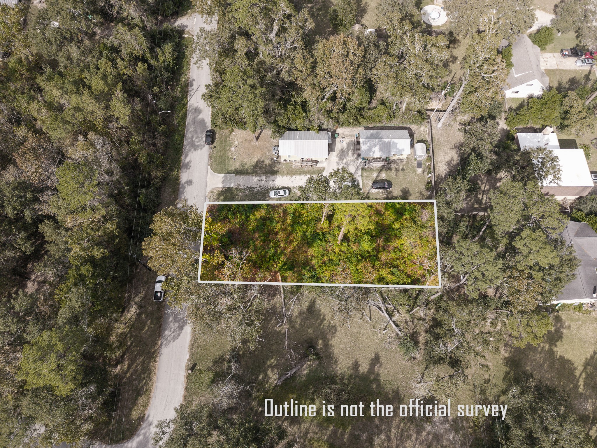 22030 Rustic Bridge Lane Houston, TX 77339 - Photo 3 of 7 This aerial photo shows a rectangular, wooded plot of land outlined for sale in a residential neighborhood. It is surrounded by trees and nearby homes, offering a peaceful setting with road access.
