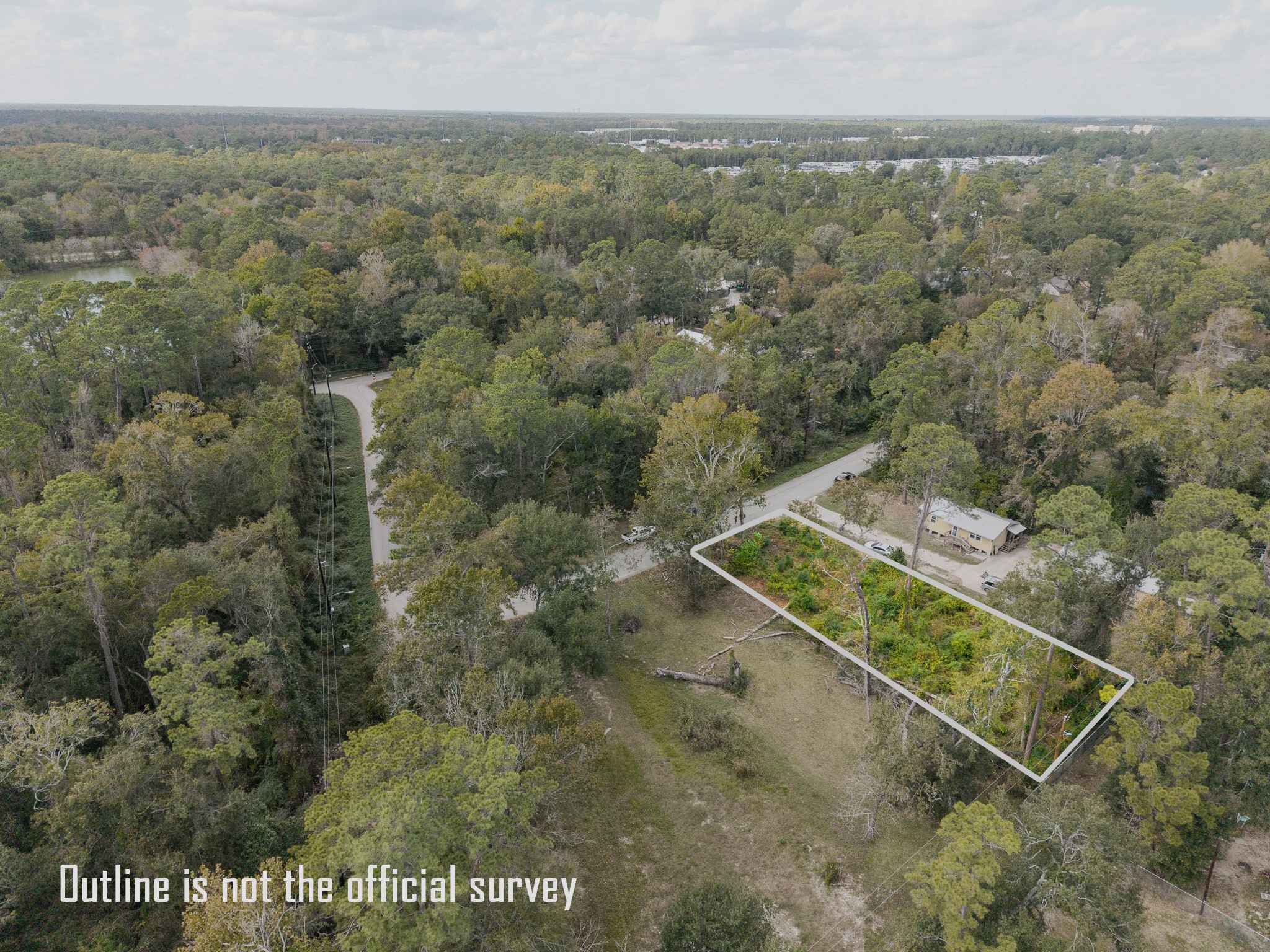 22030 Rustic Bridge Lane Houston, TX 77339 - Photo 7 of 7 This photo shows a rectangular plot of land outlined in a wooded area, suggesting a peaceful, natural setting. Nearby roads and a few houses are visible, indicating a secluded yet accessible location.