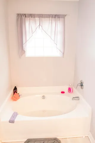 a bathroom with a tub and a window