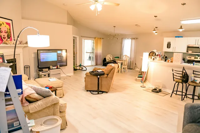 a living room with furniture a flat screen tv and kitchen view
