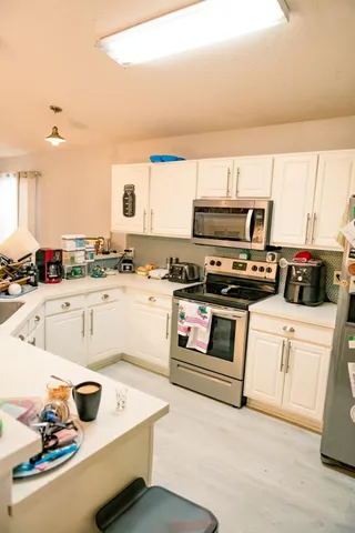 a kitchen with stainless steel appliances a stove top oven and a refrigerator