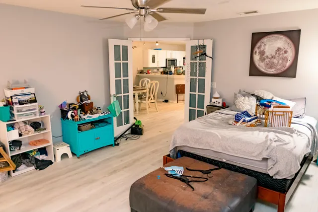 a bedroom with a bed and wooden floor