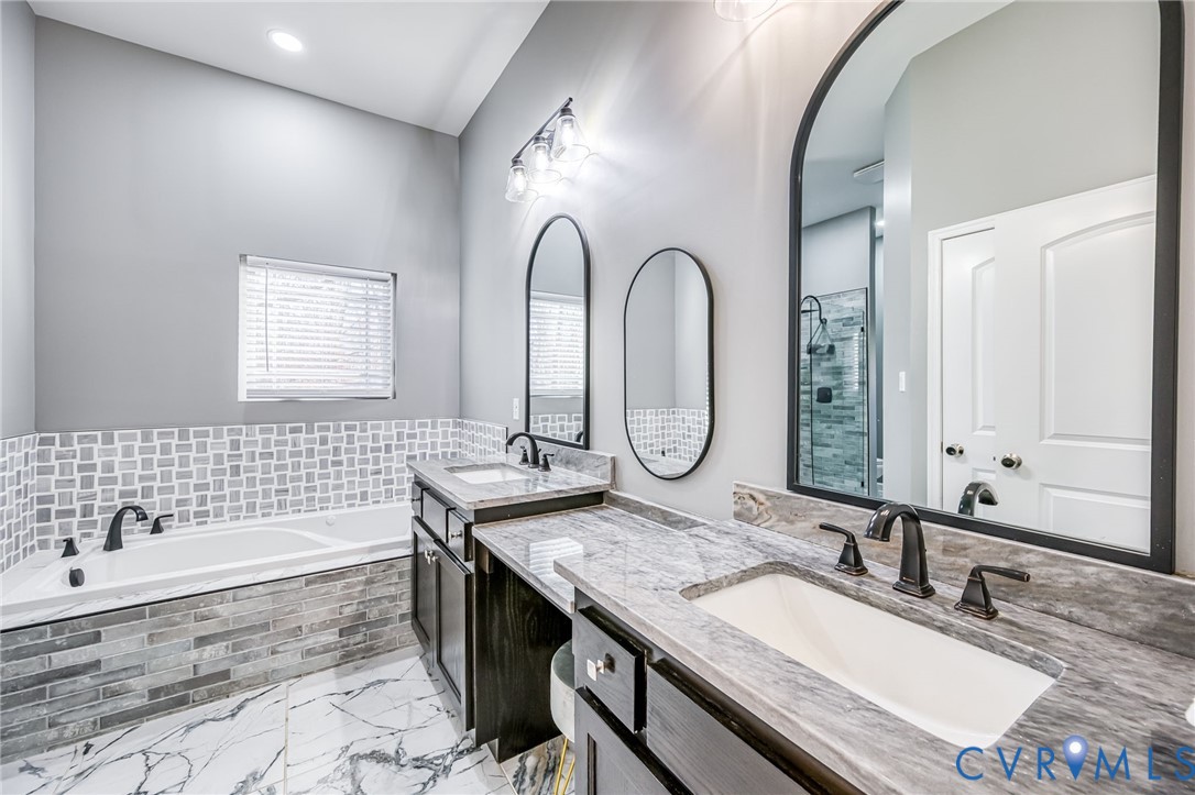 11534 Georgetown Road Mechanicsville, VA 23116 - Photo 19 of 37 a bathroom with a granite countertop tub a double vanity sink and a mirror