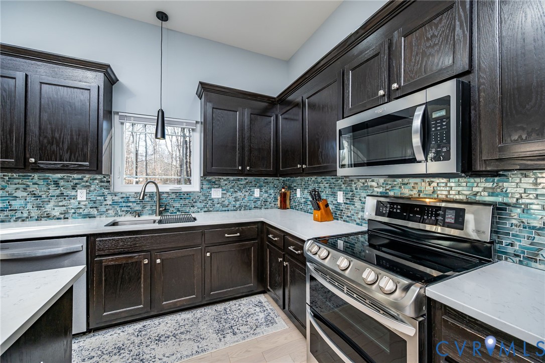 11534 Georgetown Road Mechanicsville, VA 23116 - Photo 7 of 37 a kitchen with stainless steel appliances kitchen island granite countertop a stove microwave and sink