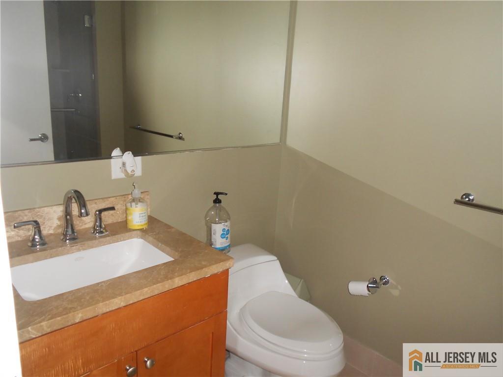 1 Spring Street, Unit 2305 New Brunswick, NJ 08901 - Photo 15 of 29 a bathroom with a sink a toilet and mirror
