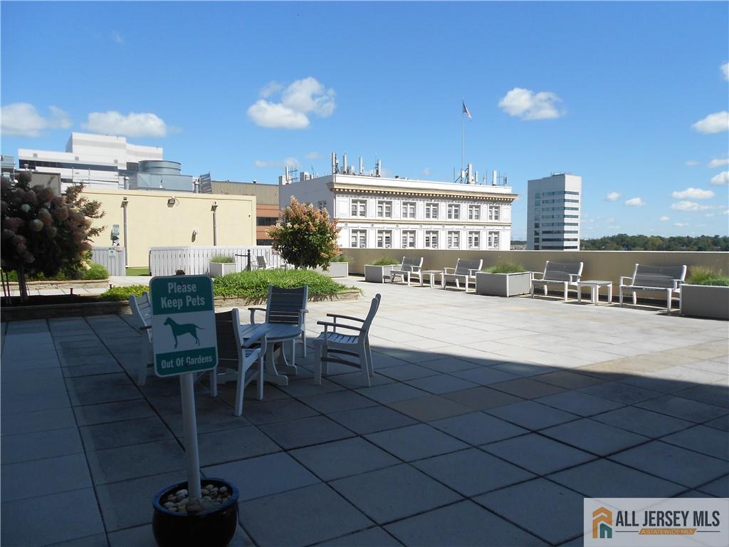 1 Spring Street, Unit 2305 New Brunswick, NJ 08901 - Photo 23 of 29 a view of a patio with dining table and chairs