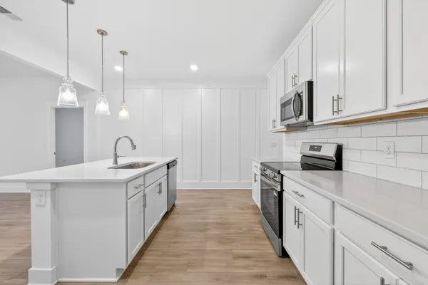 a kitchen with stainless steel appliances granite countertop a sink stove and refrigerator