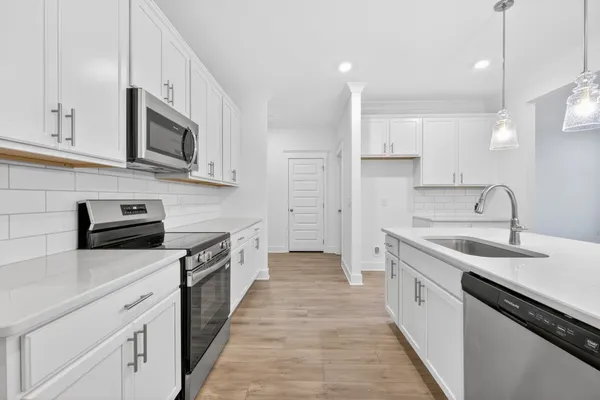 a kitchen with stainless steel appliances white cabinets and a stove top oven