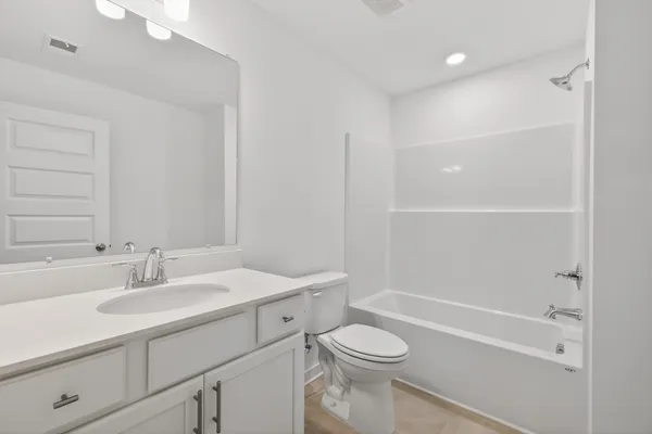 a bathroom with a sink toilet vanity and shower