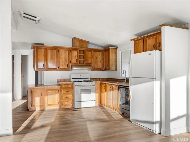 a kitchen with granite countertop a refrigerator stove top oven and sink