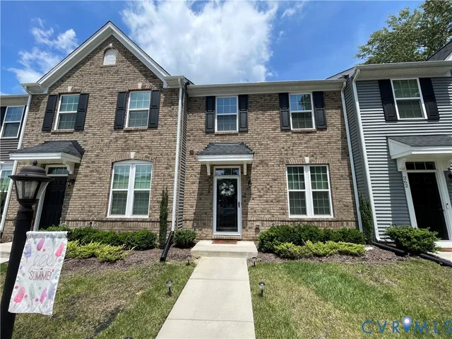 a front view of a house with yard and trees
