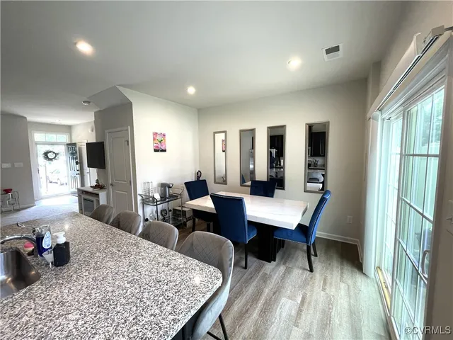 a room with a table chairs and wooden floor