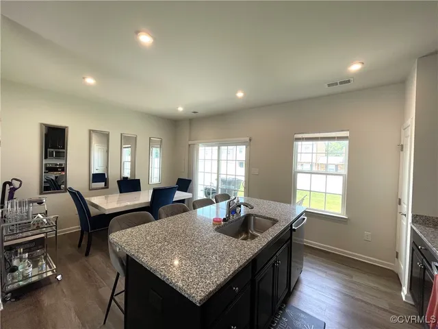 a dining hall with granite countertop wooden floor dining table and chairs