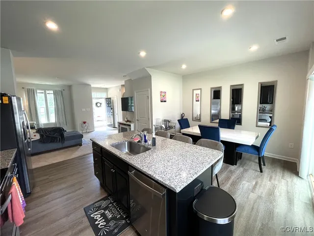 a large kitchen with kitchen island a stove a sink a dining table and chairs